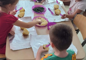 Dzieci, które z wielkim zapałem przygotowują pieczone ziemniaki.