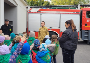 Dzieci słuchający o trudnej i niebezpiecznej pracy strażaka.