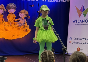 Dziewczynka recytująca wiersz na scenie podczas IV Warszawskiego Konkursu Recytatorskiego w Dzielnicy Wilanów.