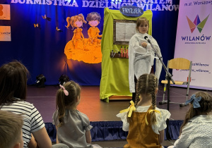 Dziewczynka recytująca wiersz na scenie podczas IV Warszawskiego Konkursu Recytatorskiego w Dzielnicy Wilanów.