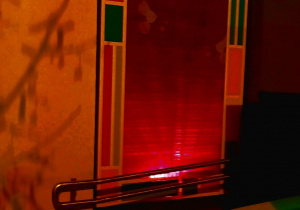 Fragment budynku przedszkola oświetlonego na czerwono.